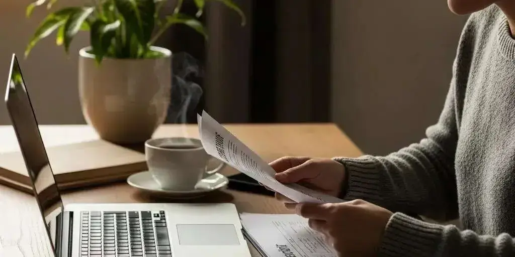Cozy workspace with a person reviewing credit repair documents on a laptop